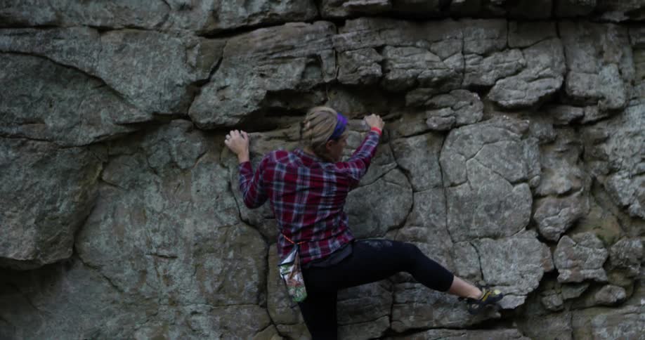 Woman rock climber using her skills to ascend