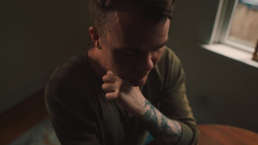 Man sitting with hand on chin in thought