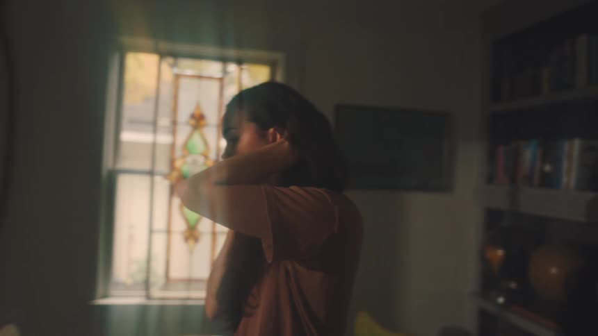Woman walking through the rooms of the house and talking on the cell phone