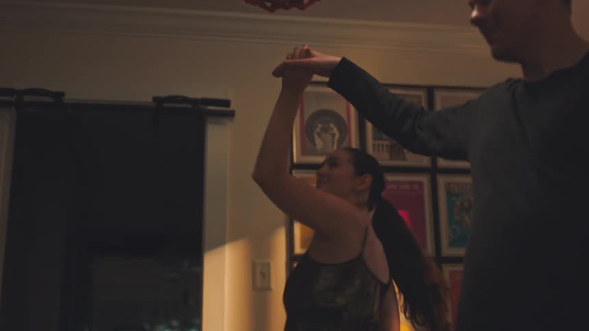 A happy couple dancing in a cozy living room