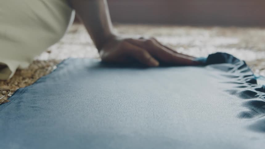 Palm of a hand passing over a blue fabric