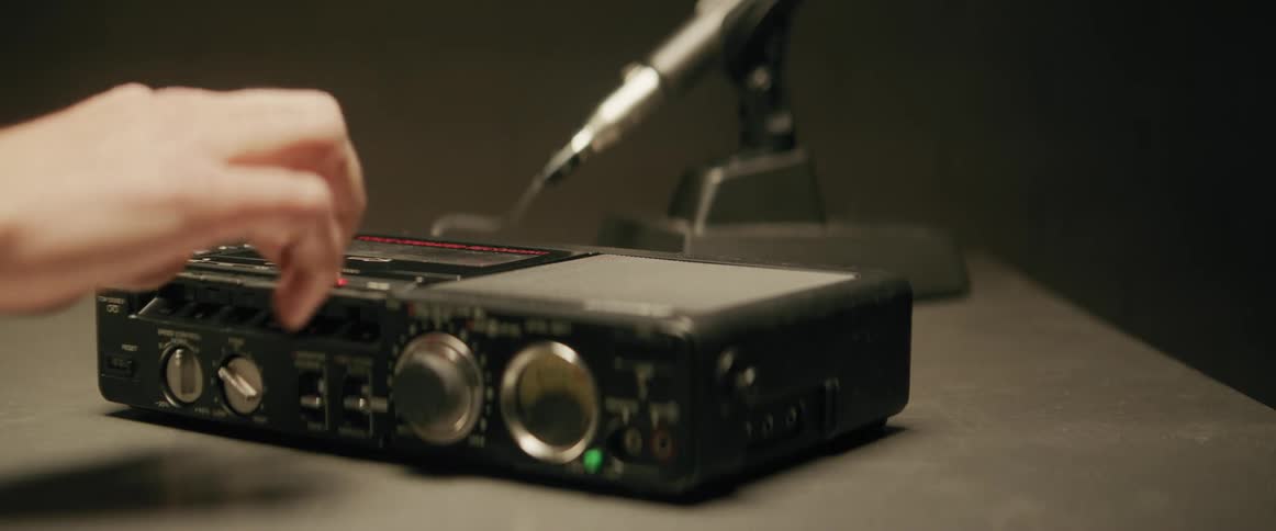 Hand placing a cassette tape into a tape player