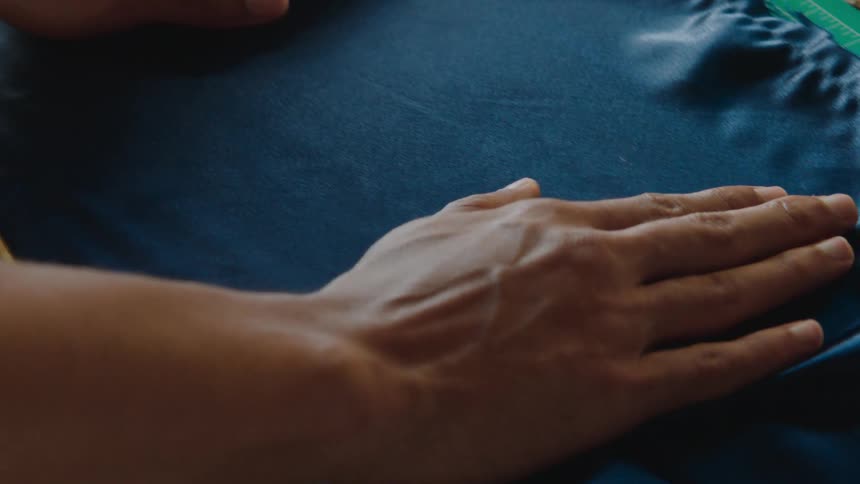 A couple of hands stretching a piece of blue fabric