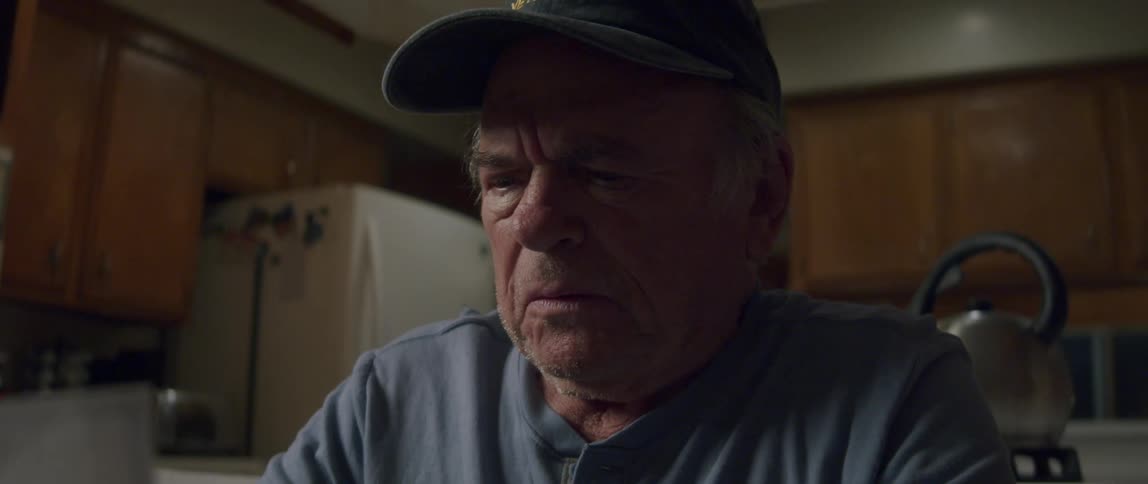 An elderly man looks shocked as he reads a letter
