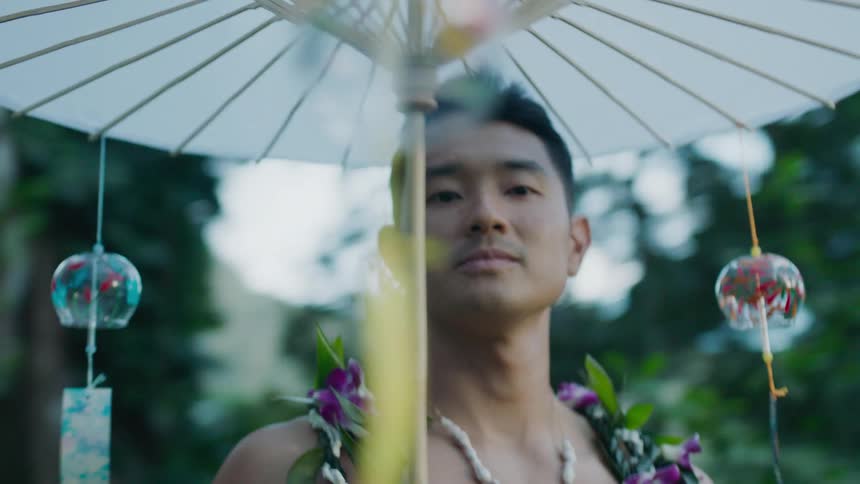 Man using oriental umbrella in an outdoor and natural environment