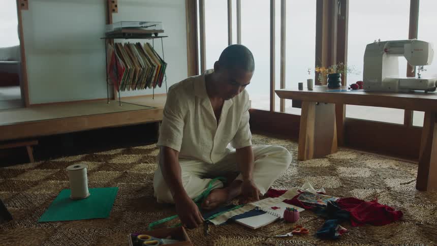 A tailor measures pieces of cloth in his workshop