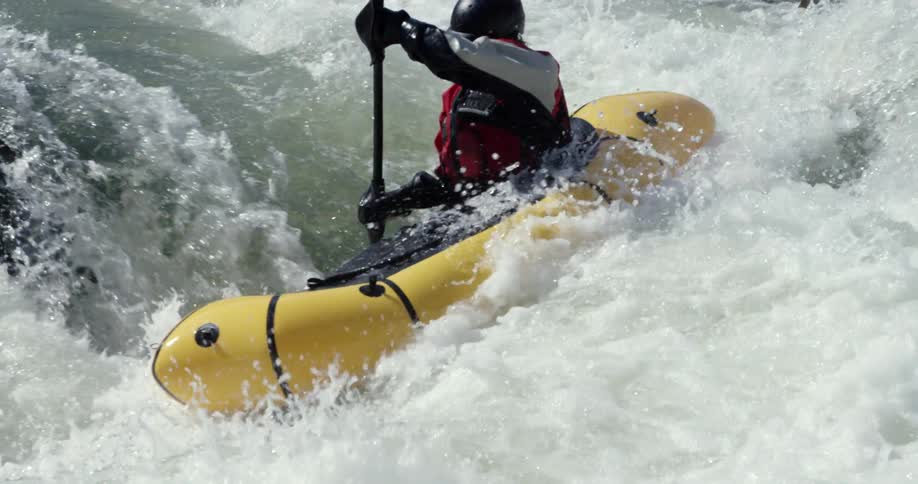 A man is kayaking down whitewater rapids