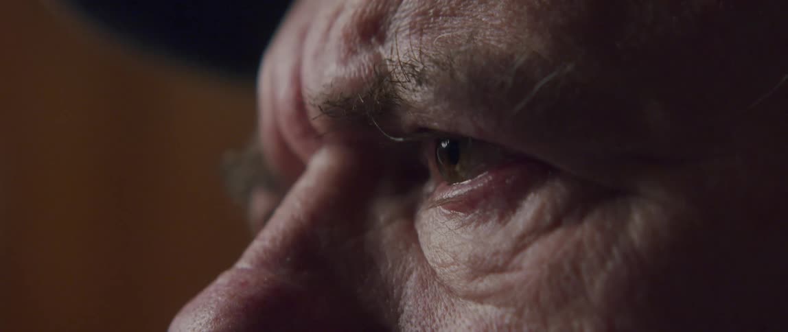 Closeup of the eyes of an elderly man who begins to cry