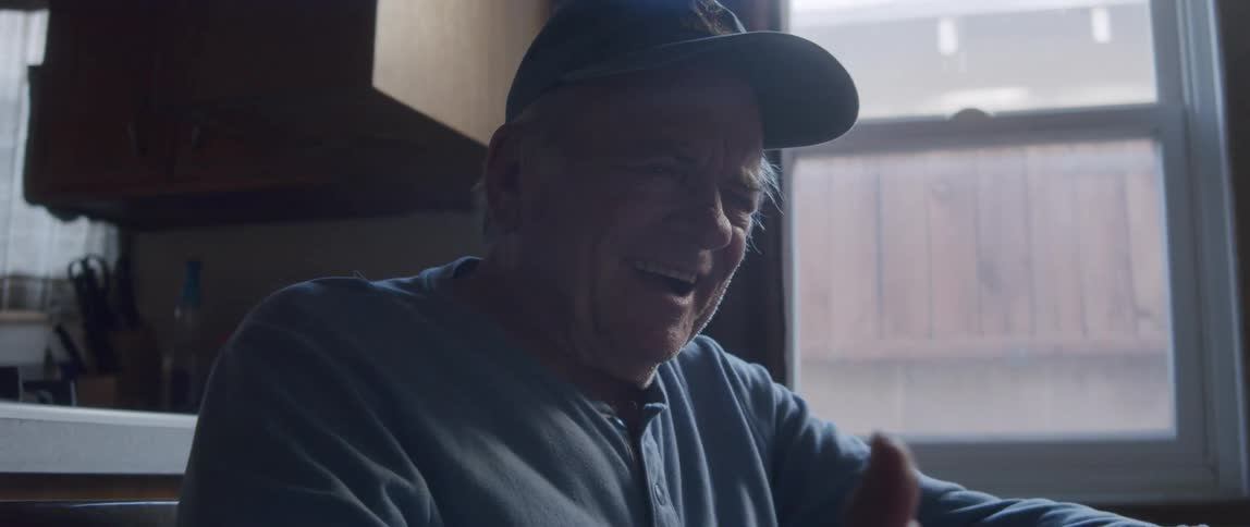 Elderly man sitting in front of a tablet