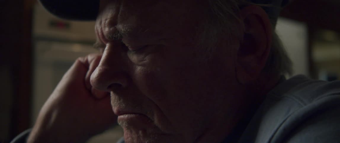 Side portrait of a dejected elderly man in a cap
