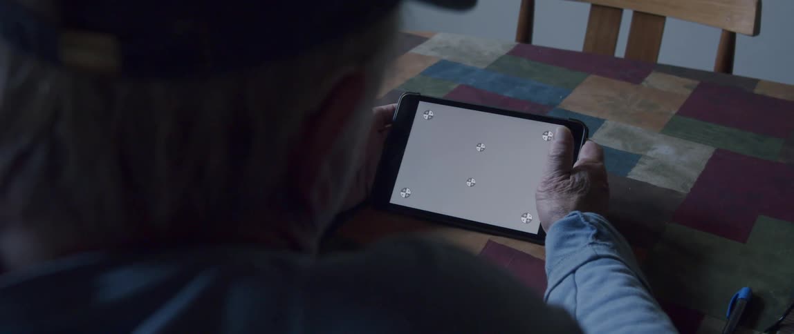 A person holds a tablet with a replaceable screen at home
