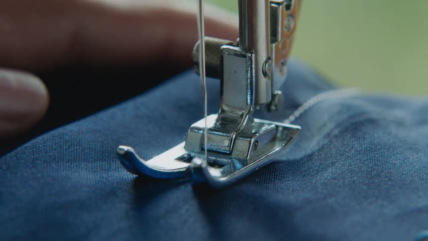 Machine sewing a blue fabric