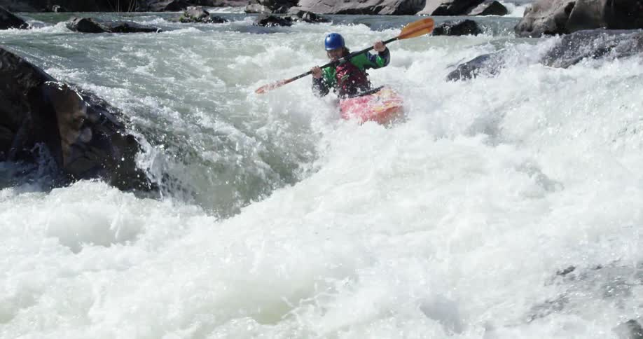 A person kayaks down a white river