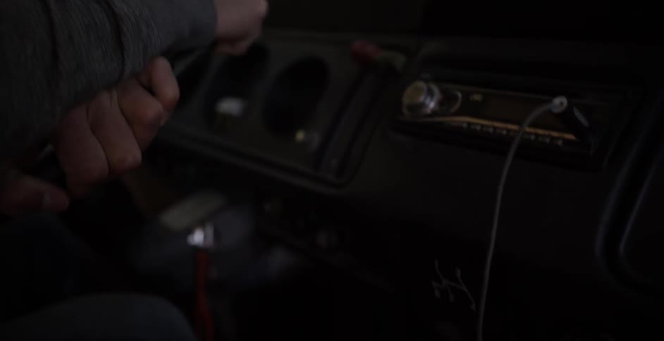 Close-up of a person's hands on their steering wheel as it's moving as seen from the passenger's area