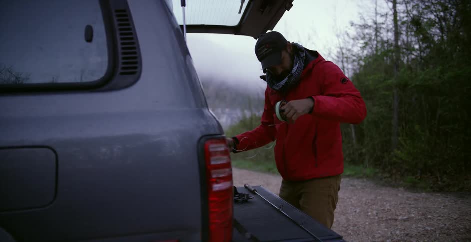 A man leans into the trunk of his truck