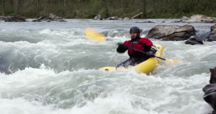 A kayaker paddles in rough rapids