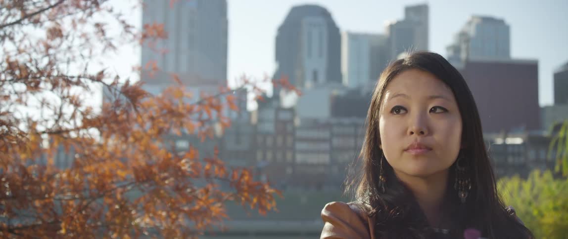 Woman standing in front of large city on an autumn day