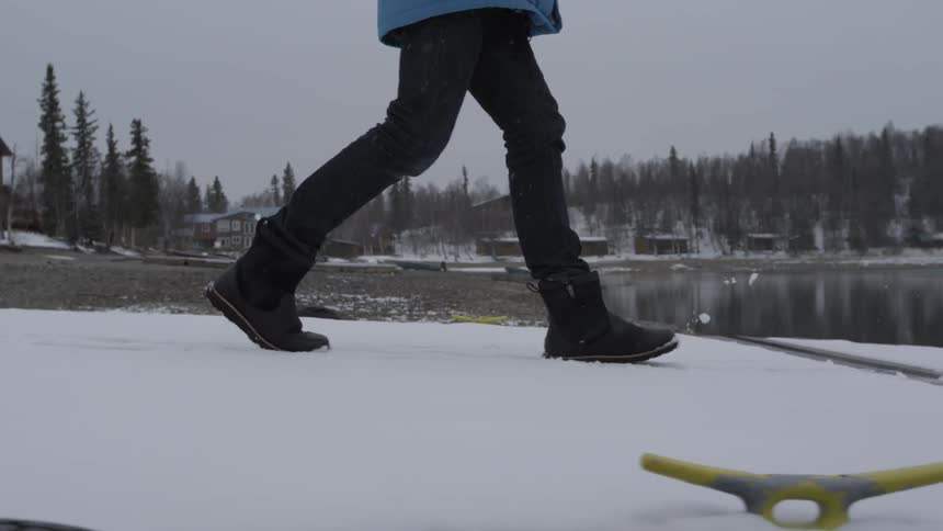 A person walks on a snow covered dock