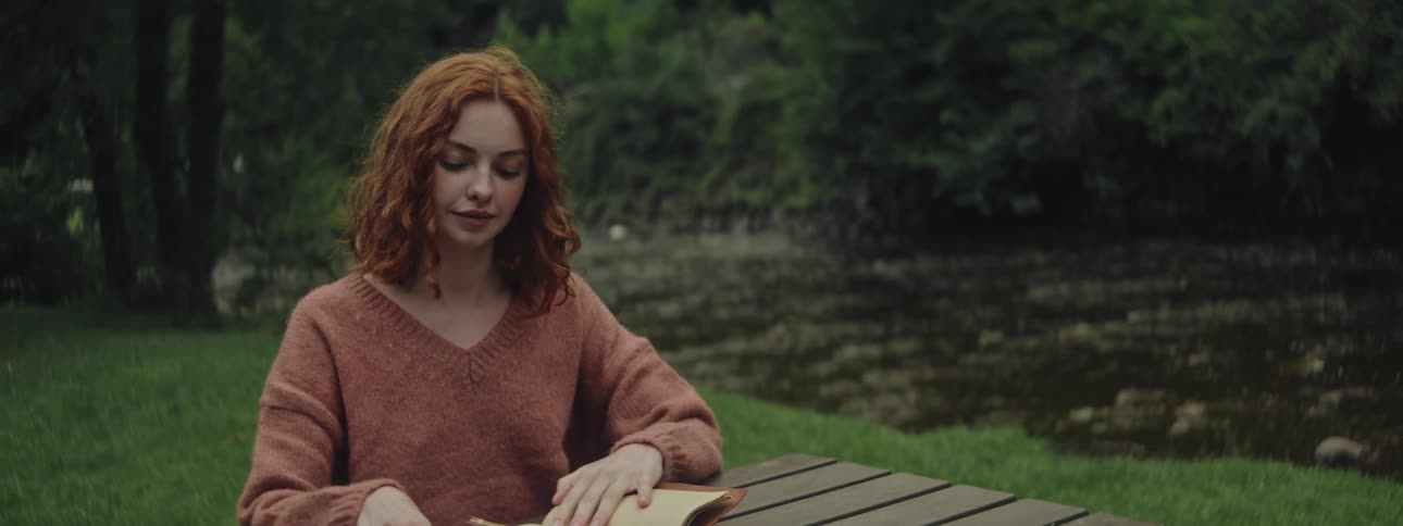 A woman is reading by the stream