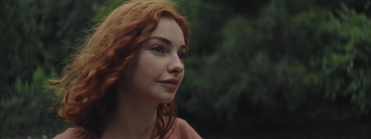 Redhead woman in a natural environment looking thoughtful