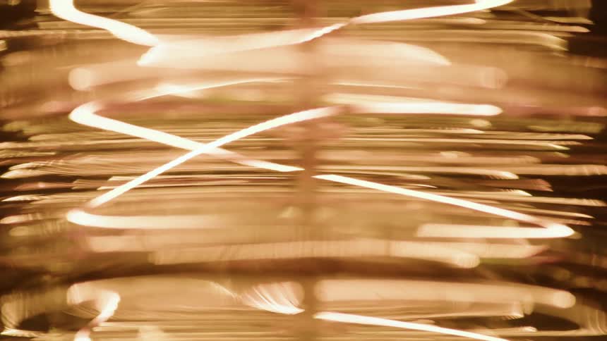 A closeup of an illuminated decorative light bulb with a unique layered shape