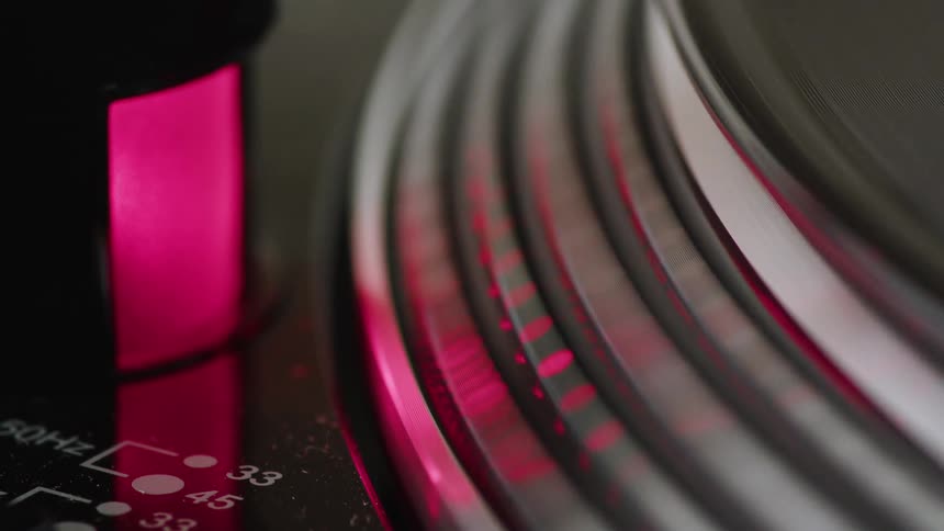 Record player light shines onto a rotating turntable while a vinyl record is being played