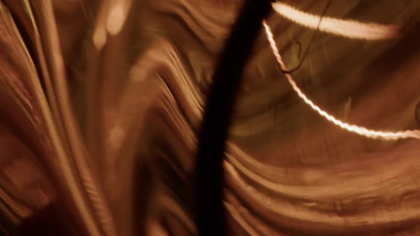 A closeup of an illuminated decorative light bulb with a unique layered shape