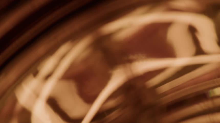 Closeup of the shiny surface of a round metal object that is reflecting the light