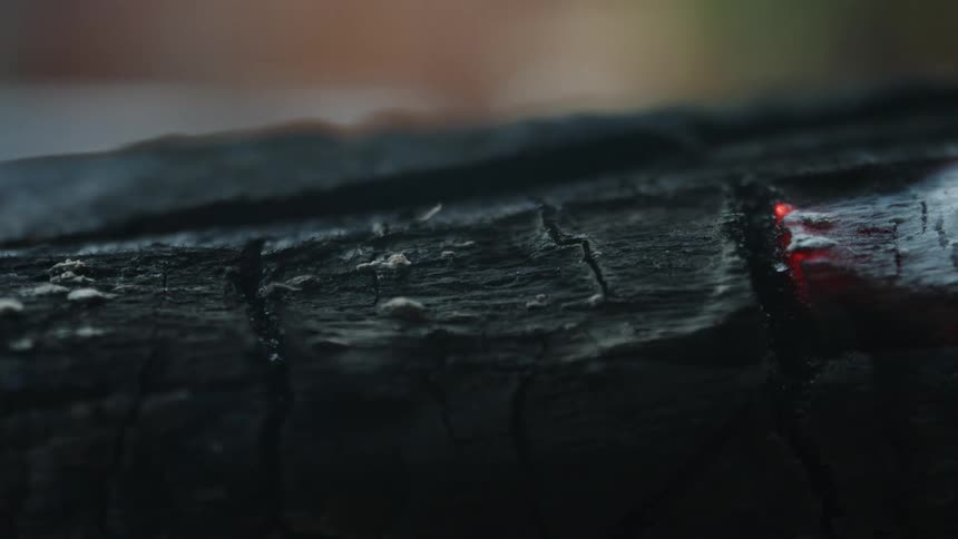 Closeup of a burnt surface still burning and emitting smoke