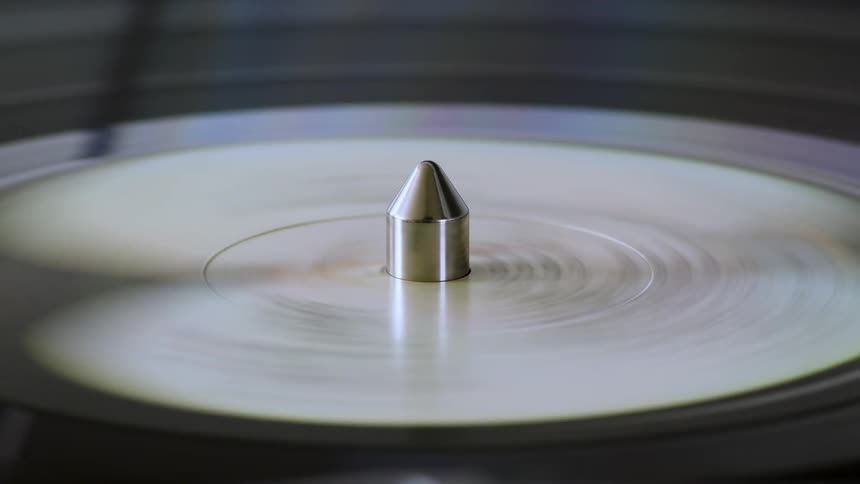 Closeup of a spinning vinyl record with a needle in the center