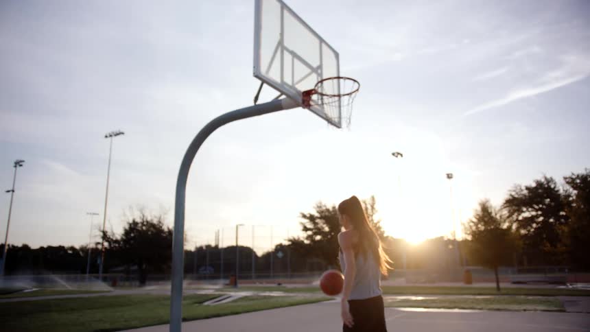 Woman throwing a ball into a basket on a basketball court