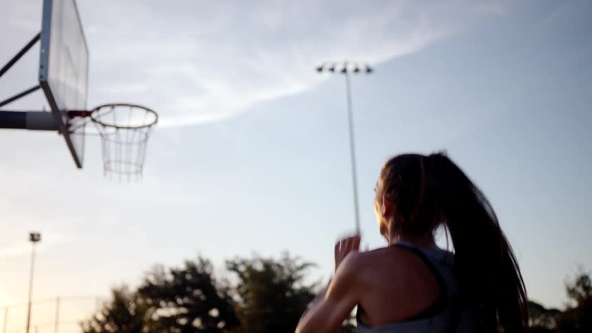 A woman shoots the basketball