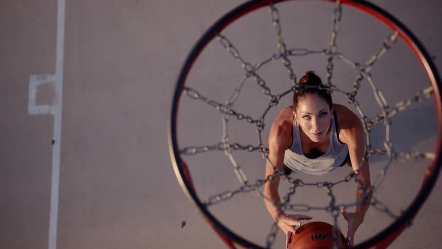 A woman prepares to shoot a basketball through a hoop