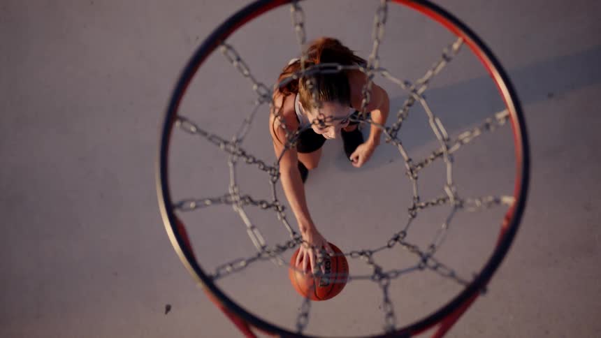 Top view of a basketball hoop and a woman with a ball