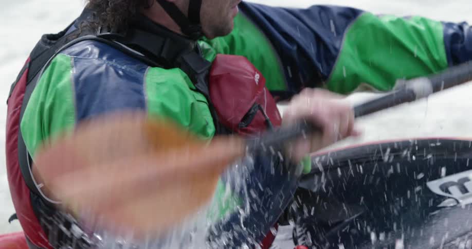 A man paddles a kayak in whitewater