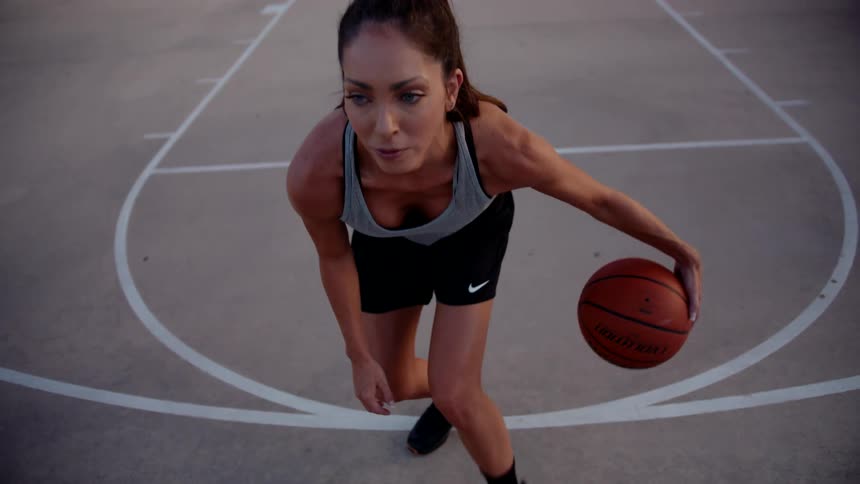 Woman dribbling a basketball on a court