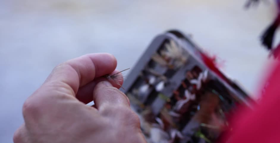 Man inspecting his wares to go fly fishing