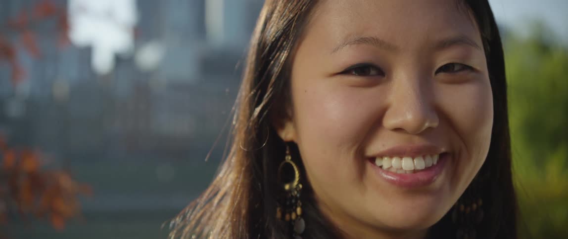 Woman with earring smiles at camera