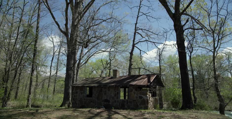 Small structure sitting in the middle of a wooded area