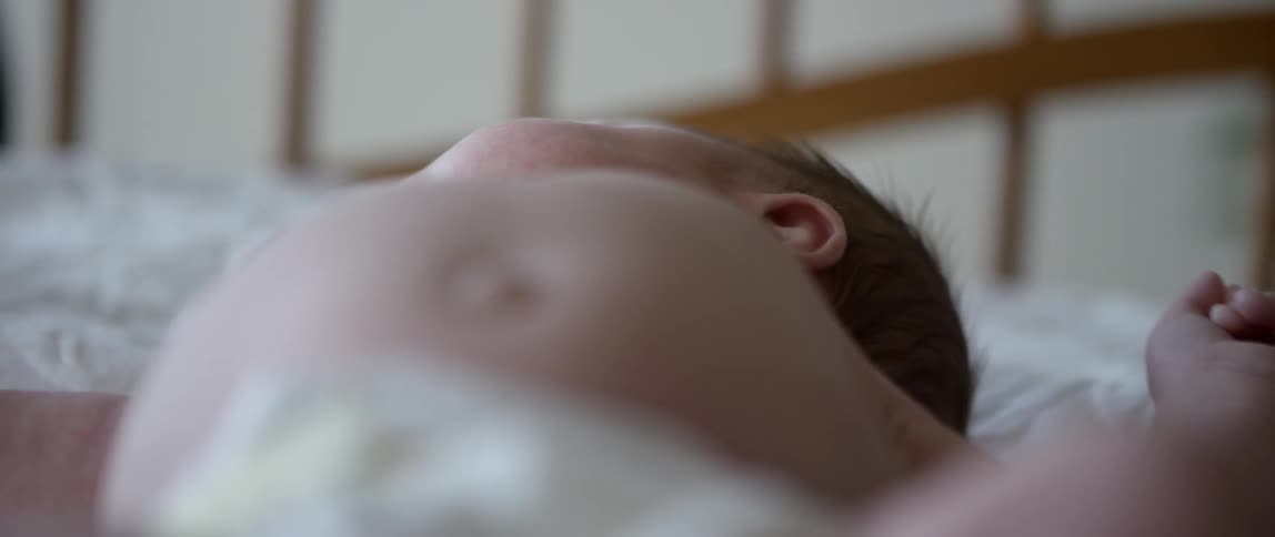Infant lying on its back as seen from the feet up