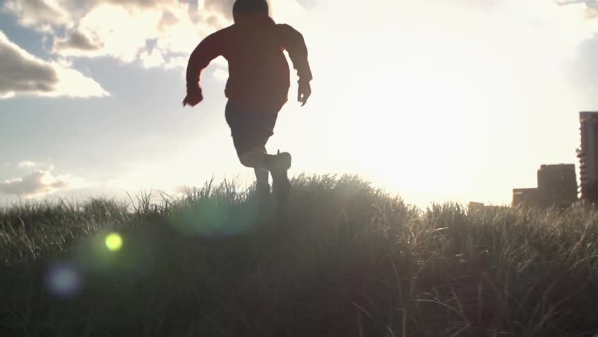 A child runs through a grassy area