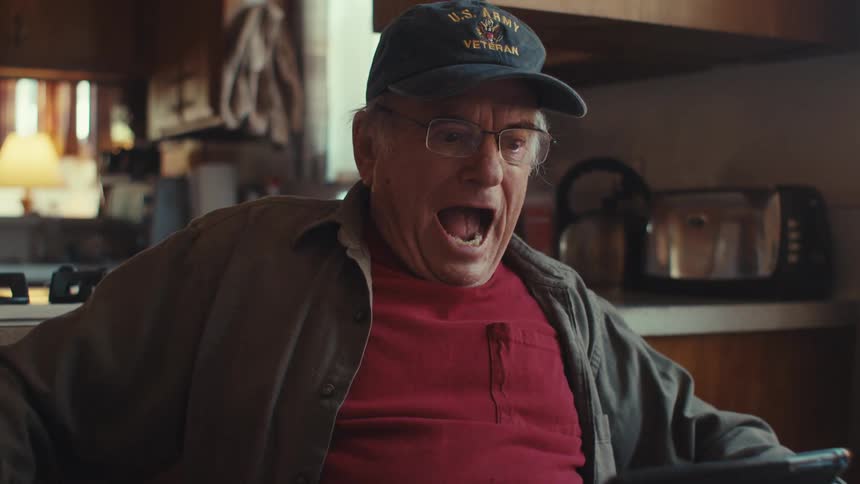 Elderly man viewing media on a tablet celebrates after being briefly shocked by an event