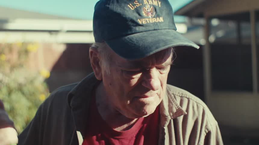 Old man works in his garden on a sunny day
