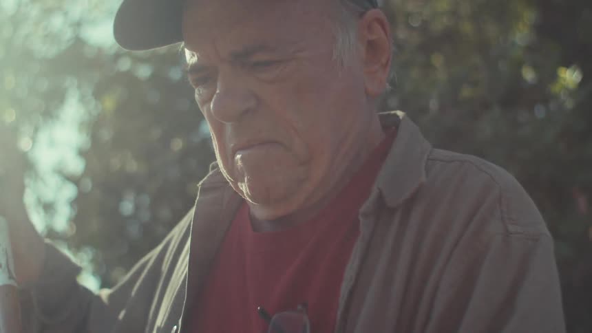 Portrait of an elderly man in a backyard during the day