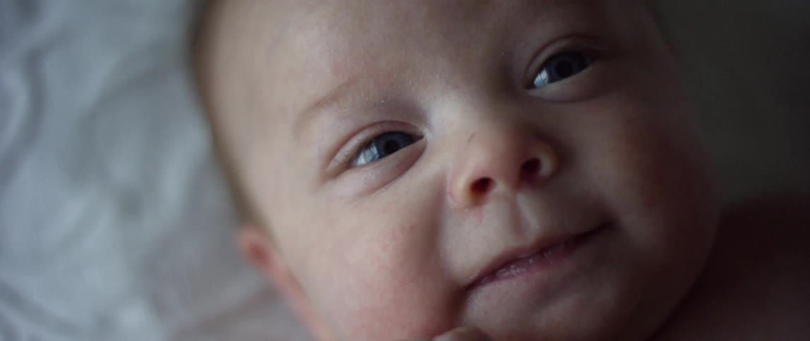 A infant is smiling at the camera