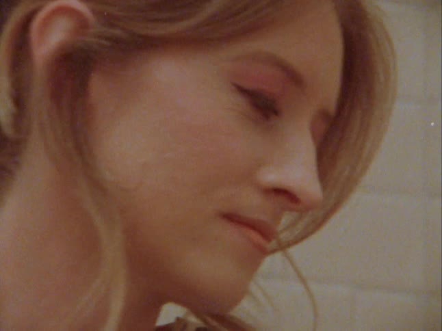 A young blonde woman turning a button on a retro radio