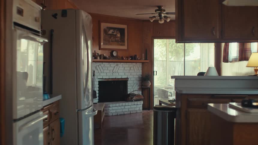 An empty kitchen and living room during day time