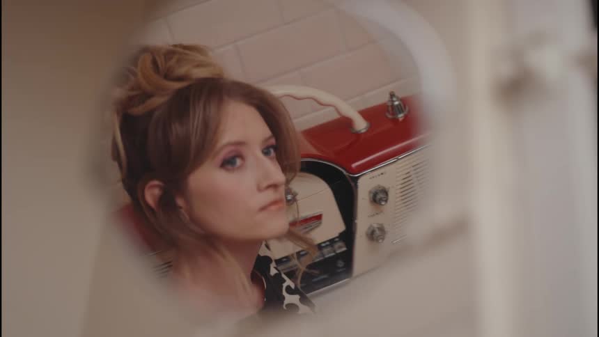 Mirrors view of a woman changing the frequency of a vintage radio