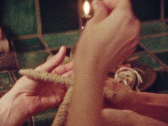 A woman puts pins in a voodoo doll