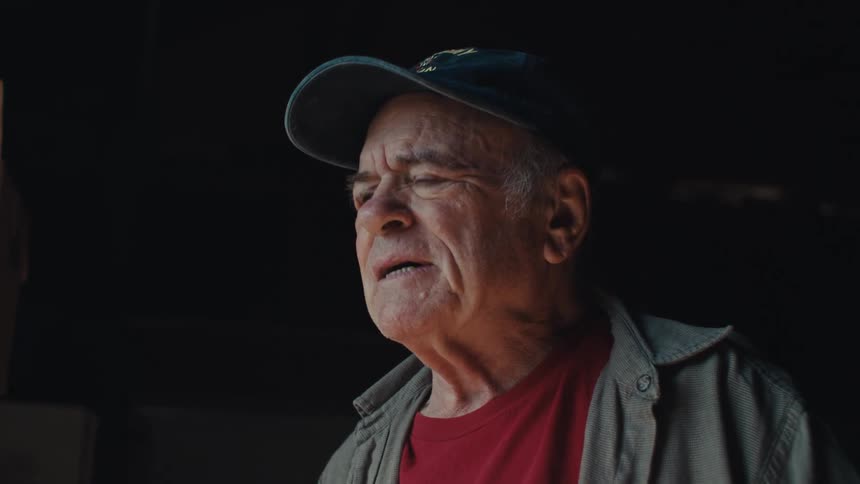 Portrait of an elderly man standing in an indoor space
